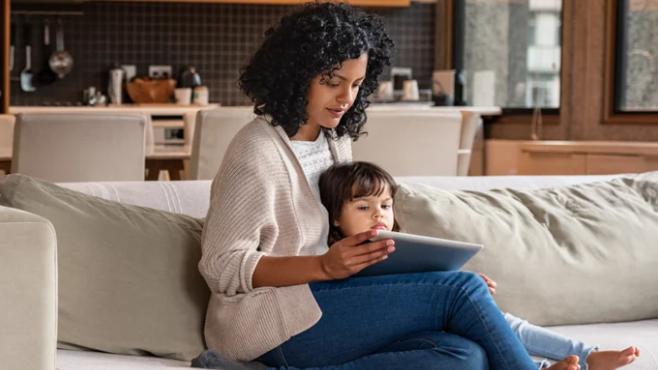 Woman and son sitting on couch reading